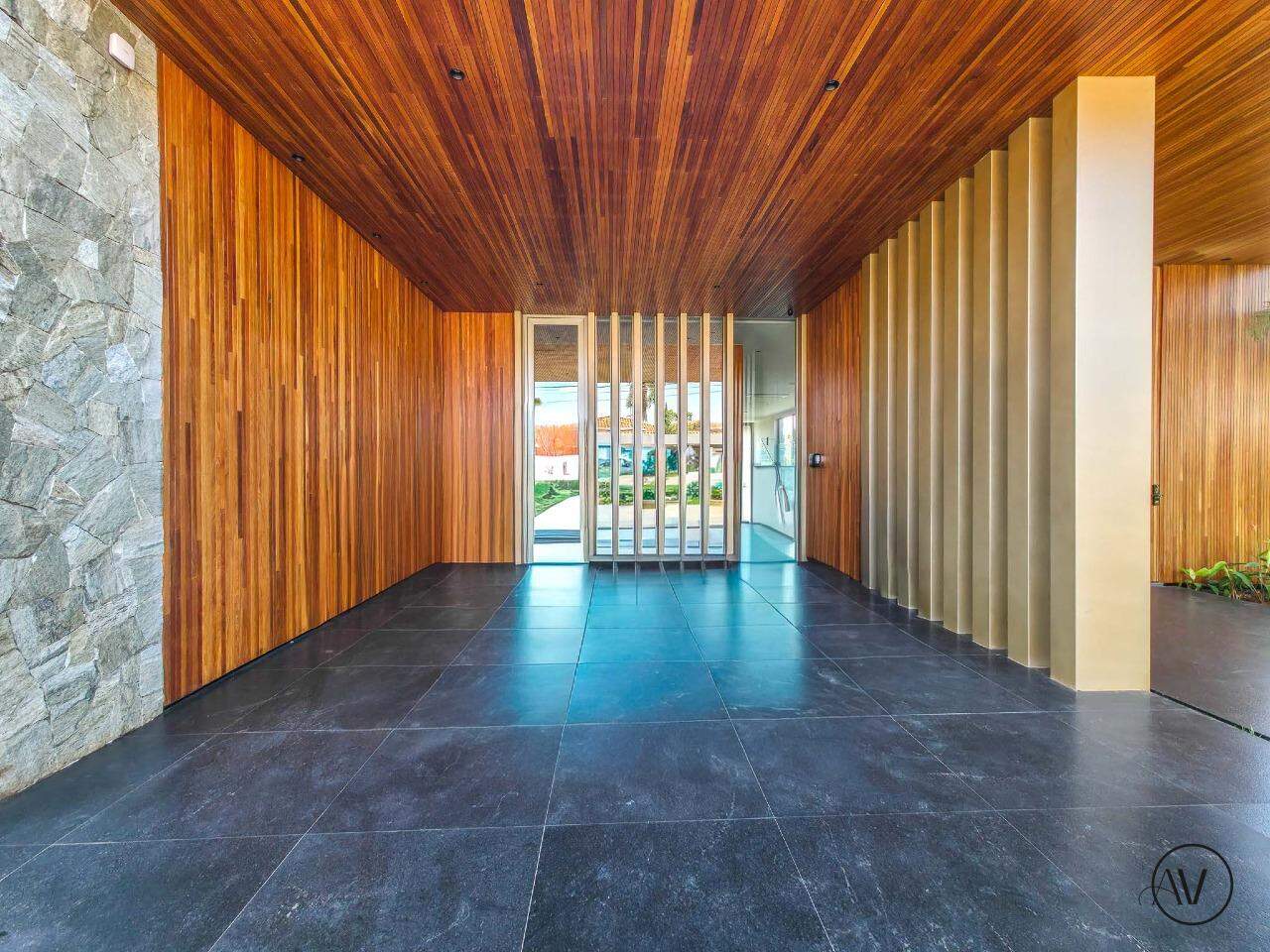 Hall de entrada com painéis de madeira e piso de pedra